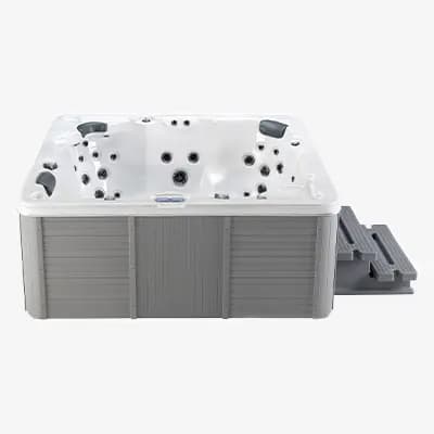 Whirlpool mit grauem Rahmen und weißen Innenwänden, mehrere Düsen, zwei Stufen auf der rechten Seite