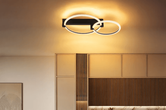 Deckenleuchte mit zwei leuchtenden Ringen über einer modernen, warm beleuchteten Wohnwand
