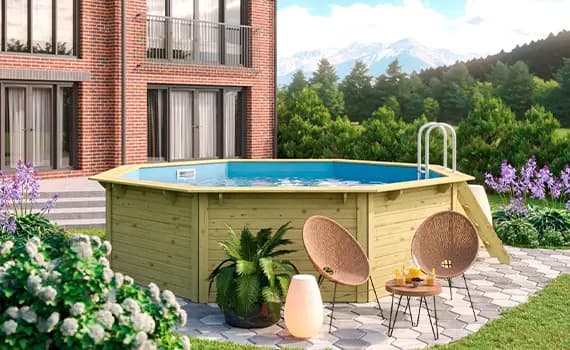 Runder Pool im Garten vor einem Ziegelhaus, zwei Stühle und Tisch mit Getränken auf gepflastertem Bereich, Berge im Hintergrund